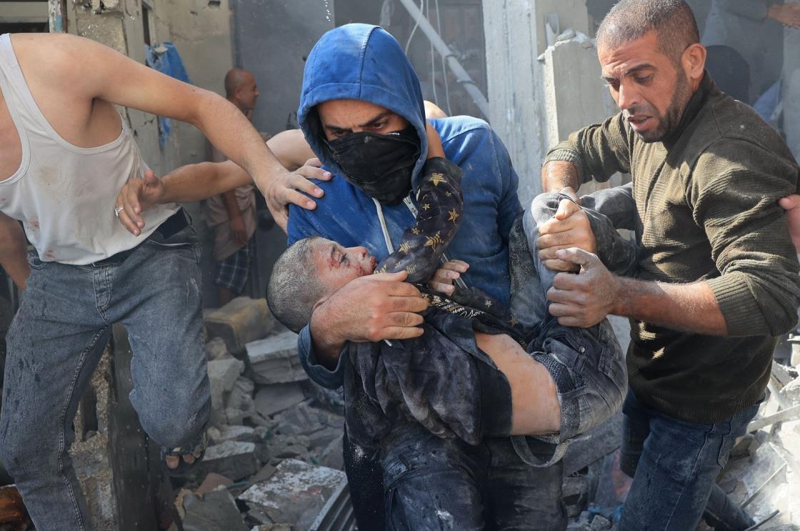 A Palestinian man carries a victim of an Israeli bombardment in Rafah, southern Gaza Strip, Palestine, Nov. 7, 2023. (AFP Photo)