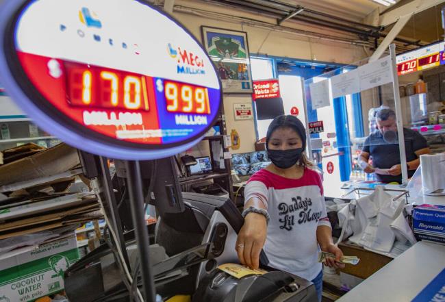 Cashier Tania Mireya pulls a lottery ticket from the printer for a customer at Super Latino Market in the Roseland neighborhood of Santa Rosa, Thursday July 28, 2022. (Chad Surmick / The Press Democrat file)