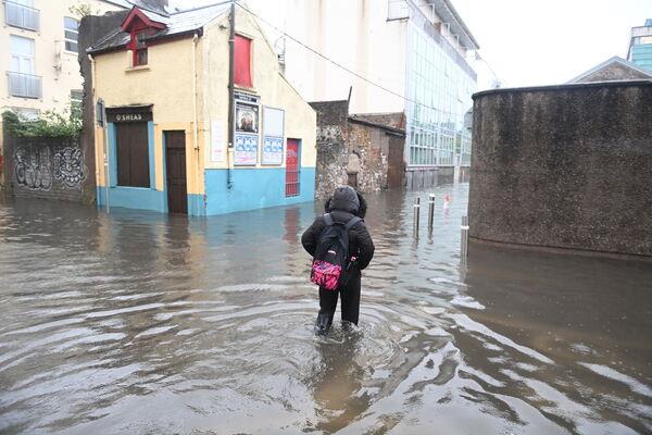 People walk through flood waters at Rutland Street in Cork. Picture: Larry Cummins People walk through flood waters at Rutland Street in Cork. Picture: Larry Cummins