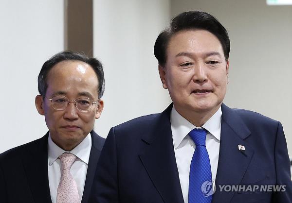 President Yoon Suk Yeol (R) enters a Cabinet meeting at the presidential office in Seoul on Nov. 28, 2023, followed by Finance Minister Choo Kyung-ho. (Yonhap)