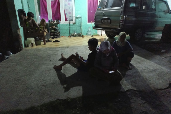 People wait outside their homes following an earthquake in Bantul district, outside Yogyakarta, Indonesia.